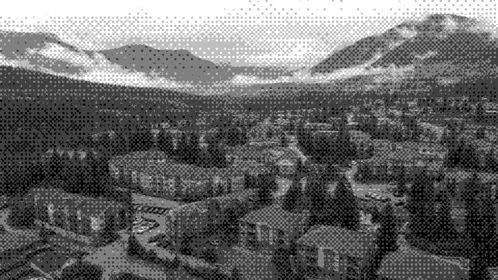 Multifamily buildings in a mountain valley under low clouds
