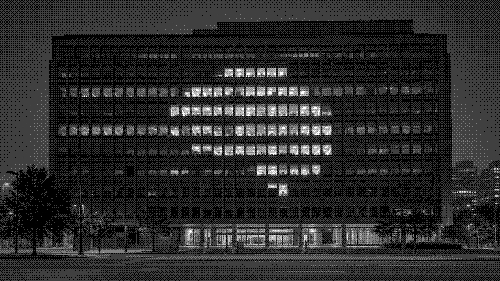 An office building at night with its lit windows forming a pattern